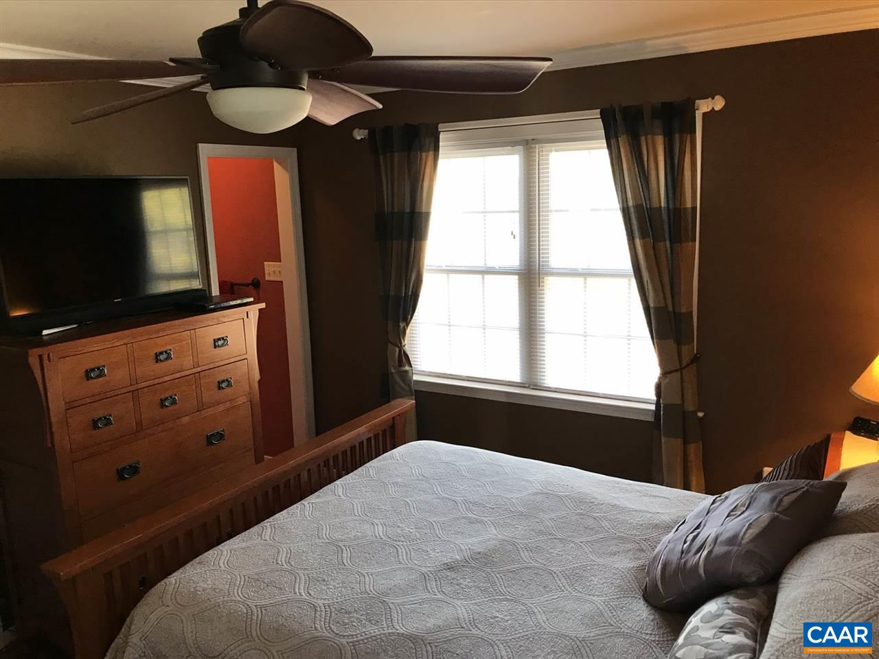 6845 Cabell Road Howardsville, VA 24562 - Photo 21 of 49 a bedroom with a bed and a flat tv screen on dresser