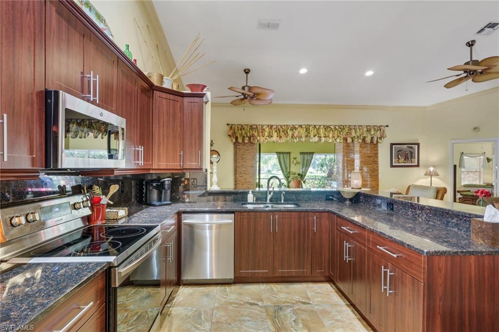 478 Countryside Drive Naples, FL 34104 - Photo 15 of 46 a kitchen with stainless steel appliances granite countertop a sink stove and cabinets