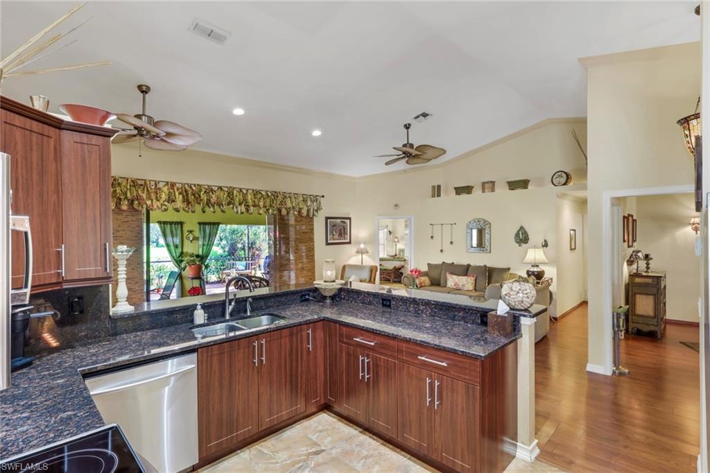 478 Countryside Drive Naples, FL 34104 - Photo 16 of 46 a kitchen with granite countertop a sink stove and cabinets