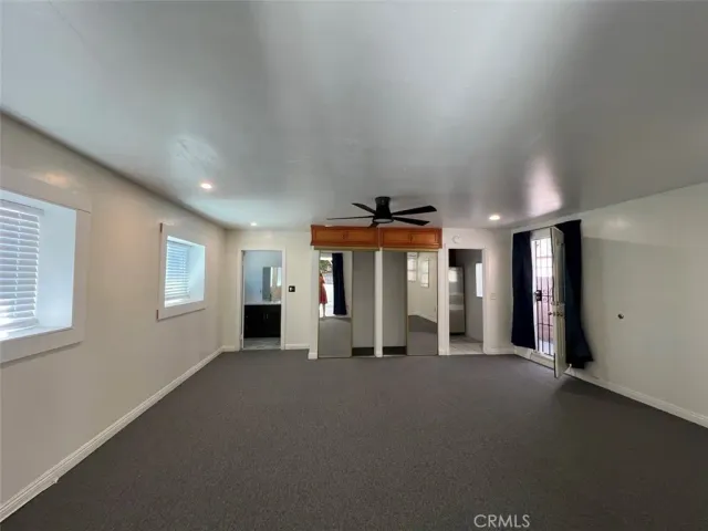 an empty room with windows and fireplace