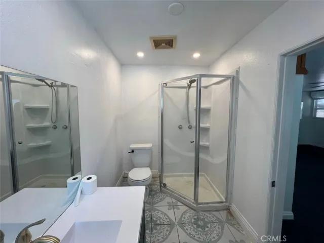 a bathroom with a shower a toilet and sink