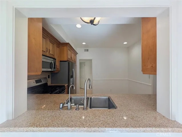 a kitchen with stainless steel appliances granite countertop a refrigerator sink and stove