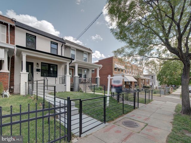 a view of a brick house with a small yard and plants