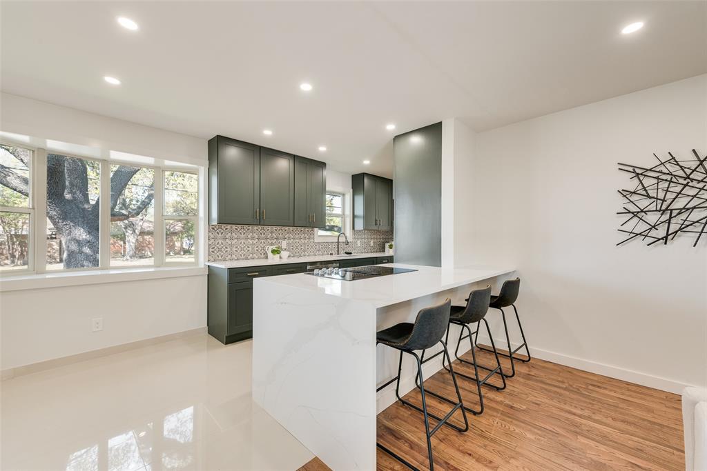 3106 Sharpview Lane Dallas, TX 75228 - Photo 13 of 31 a kitchen with stainless steel appliances kitchen island hardwood floor sink stove and table