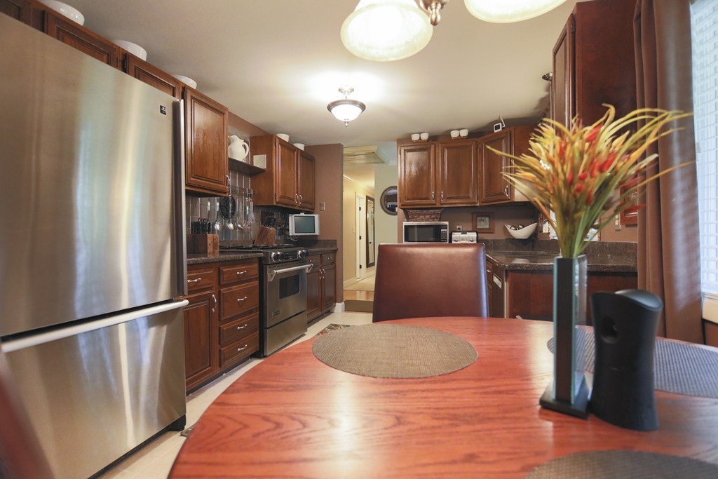 107 Park Road Chelmsford, MA 01824 - Photo 3 of 17 a kitchen with stainless steel appliances granite countertop a refrigerator a stove and a refrigerator