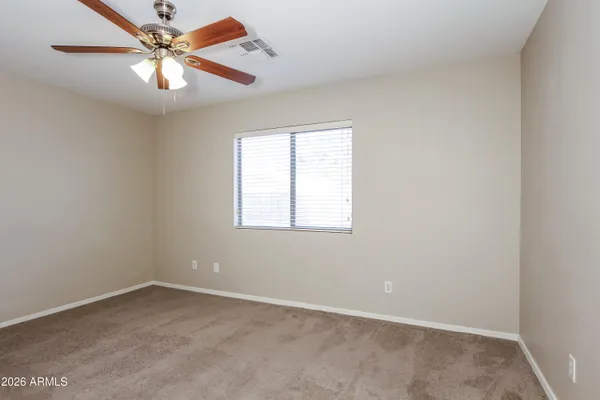 an empty room with a window and a fan
