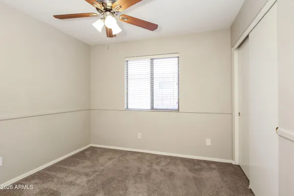 an empty room with a window and a fan