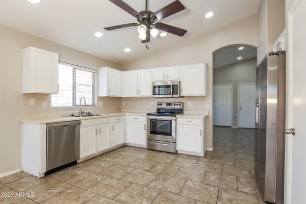 a kitchen with white cabinets and white appliances