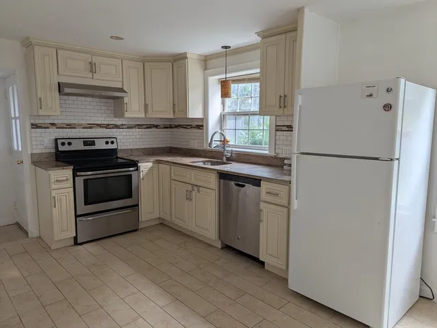 a kitchen with white cabinets and white appliances