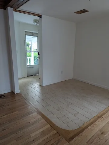 a view of a hallway with wooden floor and a window