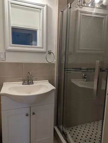 a bathroom with a sink a mirror and shower