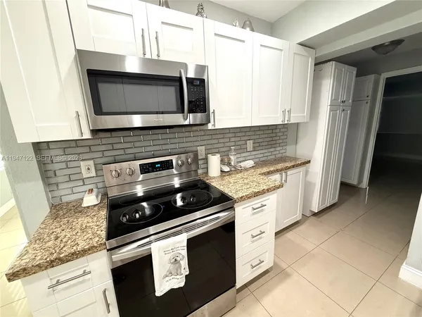 a kitchen with granite countertop a stove and a microwave