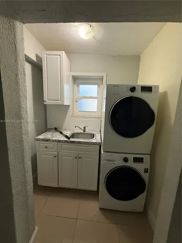 a utility room with sink dryer and washer