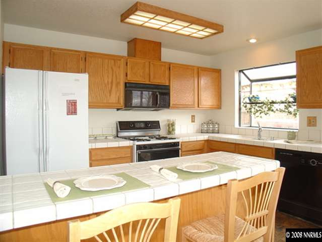 5877 Bankside Way Reno, NV 89523 - Photo 4 of 9 a kitchen with stainless steel appliances a stove a sink and a microwave