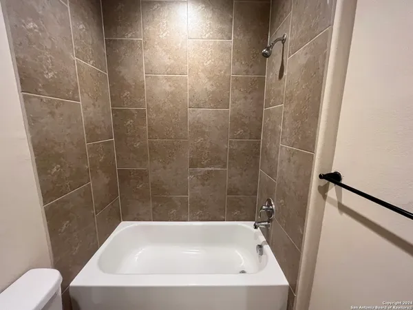 a bath tub sitting next to a white sink and toilet
