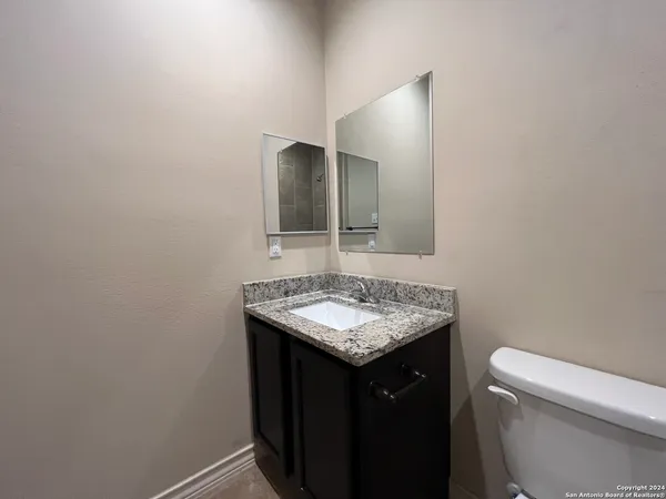 a bathroom with a sink toilet and mirror