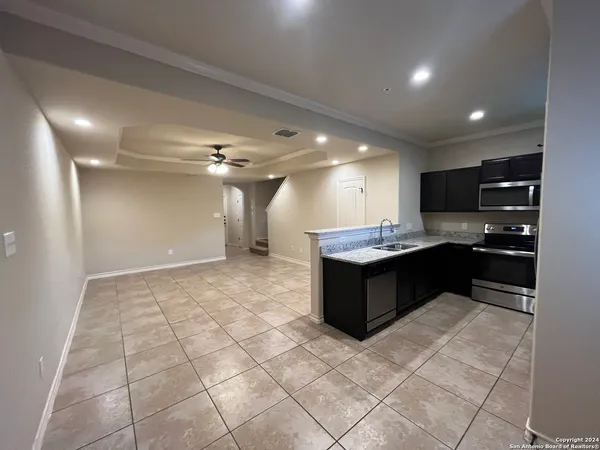 a large white kitchen with a large counter top and stainless steel appliances