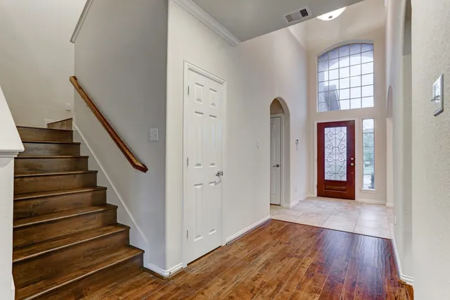 a view of a hallway with wooden floor and staircase