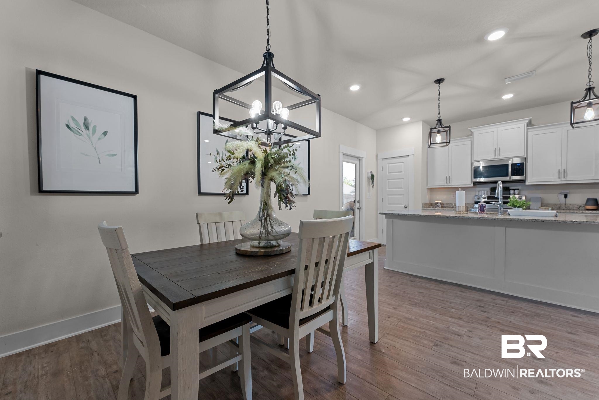 16607 Prado Loop Loxley, AL 36551 - Photo 11 of 46 Open-concept dining area featuring wood-finish flooring, a contemporary black metal chandelier, and recessed lighting