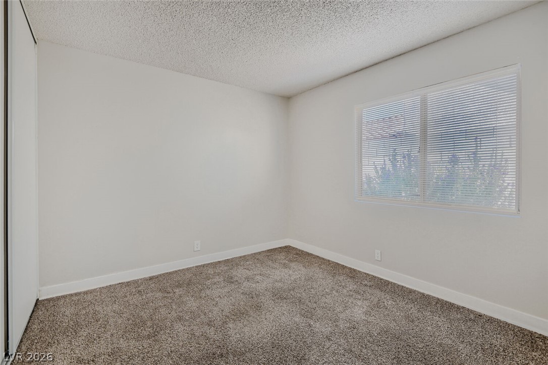 2343 Valleywood Road Henderson, NV 89014 - Photo 13 of 29 A well-lit bedroom with fresh carpeting awaits your personal touch.