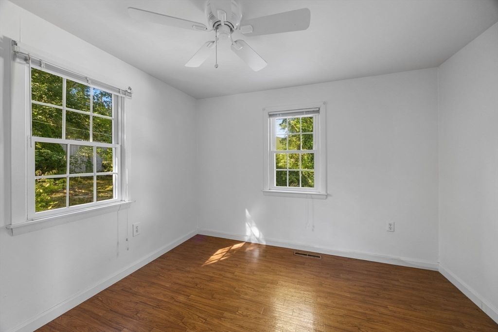 12 Spoonbill Road Dennis, MA 02670 - Photo 19 of 26 an empty room with wooden floor chandelier and windows