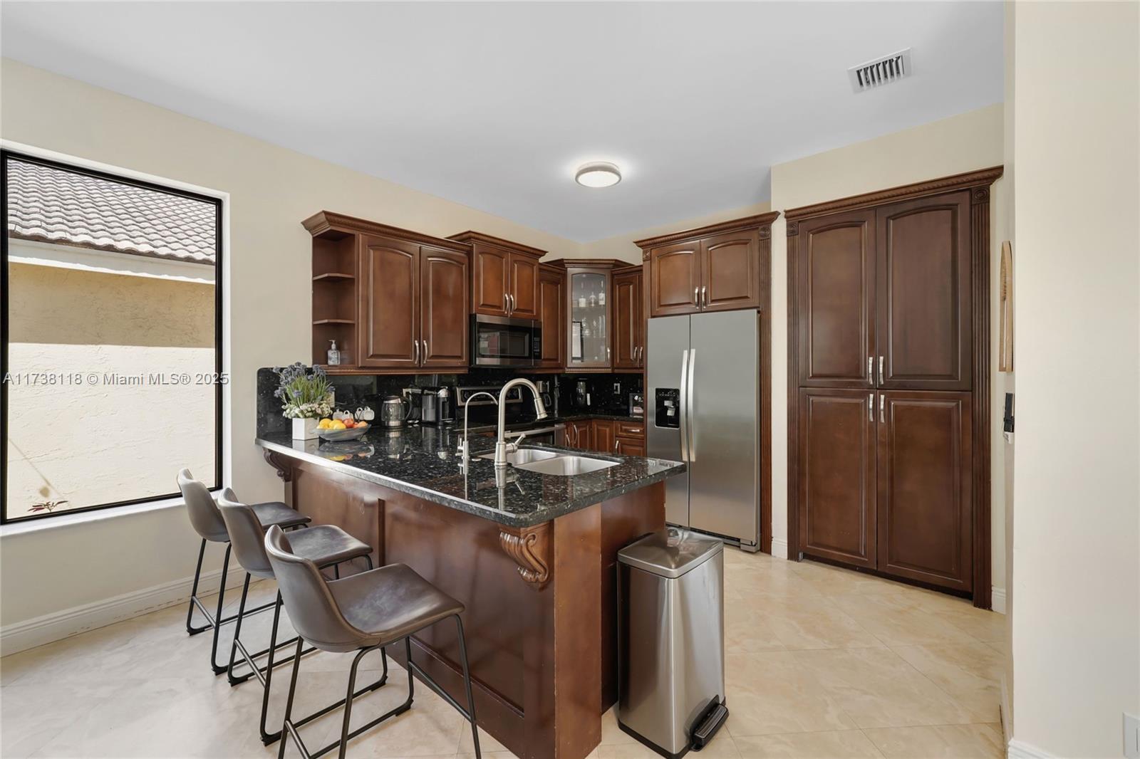 Silver Shores Miramar, FL 33027 - Photo 14 of 42 a kitchen with stainless steel appliances granite countertop a refrigerator and a stove top oven