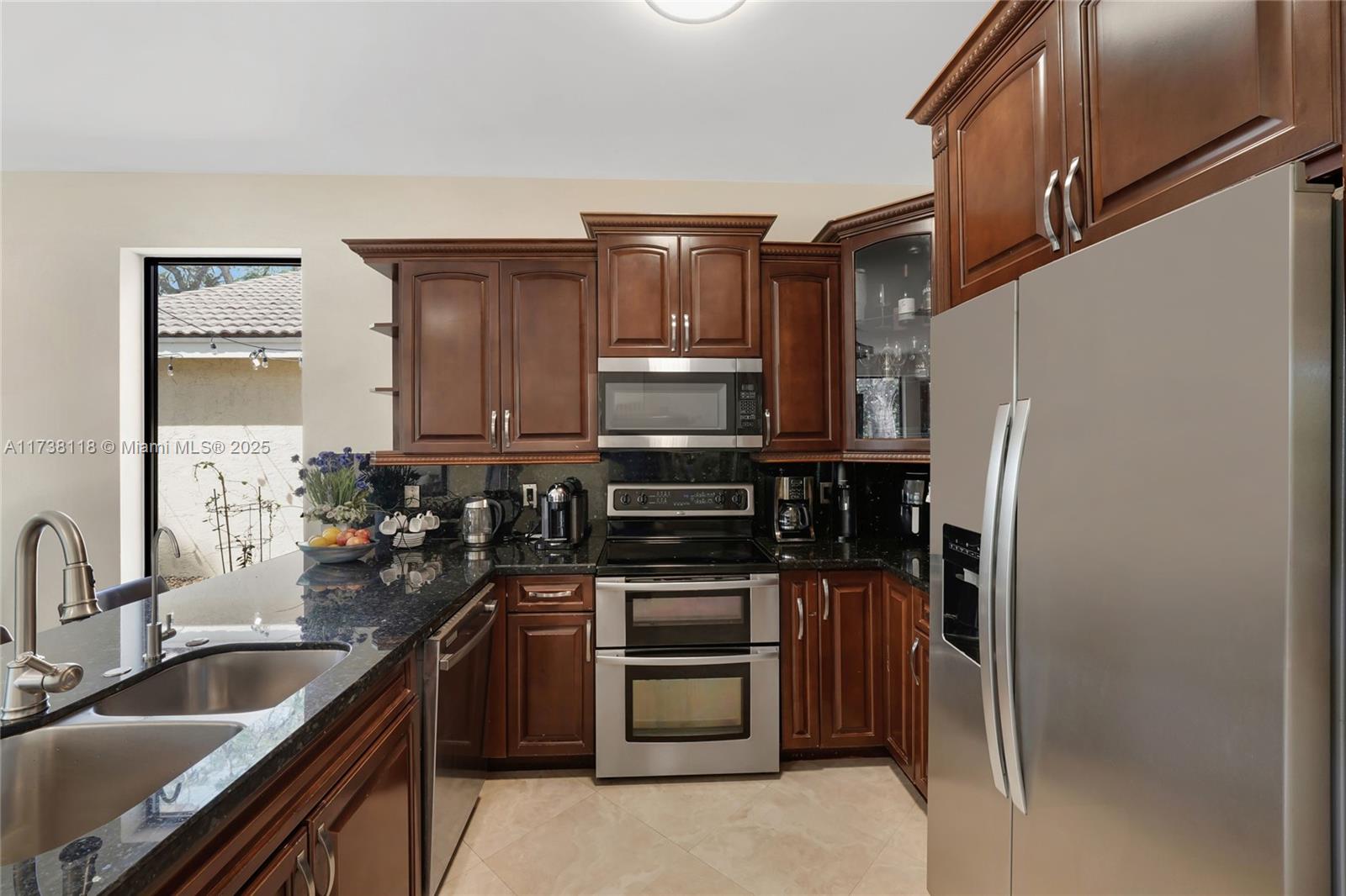 Silver Shores Miramar, FL 33027 - Photo 16 of 42 a kitchen with granite countertop a refrigerator stove and sink