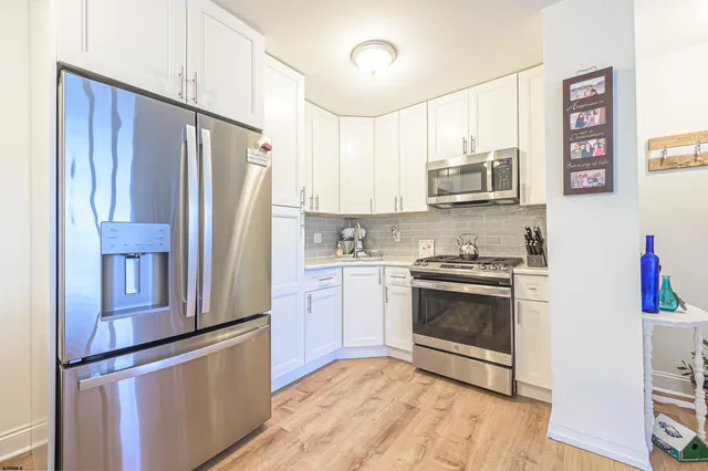 a kitchen with stainless steel appliances granite countertop a refrigerator sink and stove