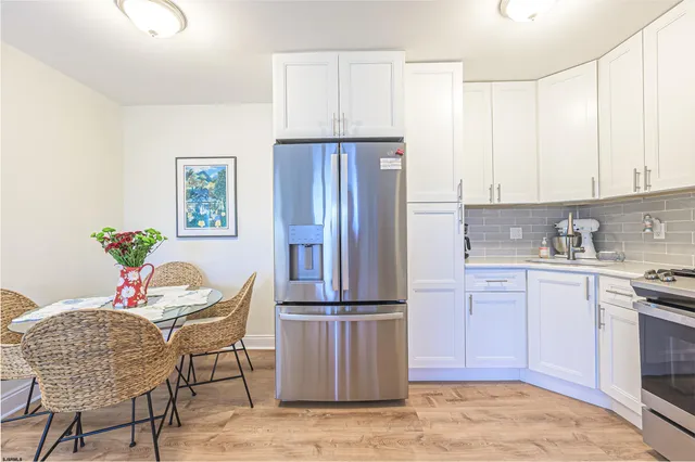a kitchen with stainless steel appliances granite countertop a refrigerator and a stove top oven