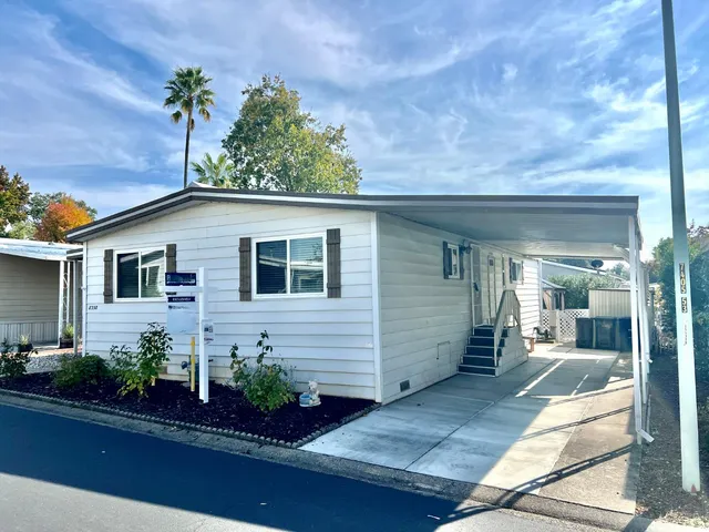 a front view of a house with plants