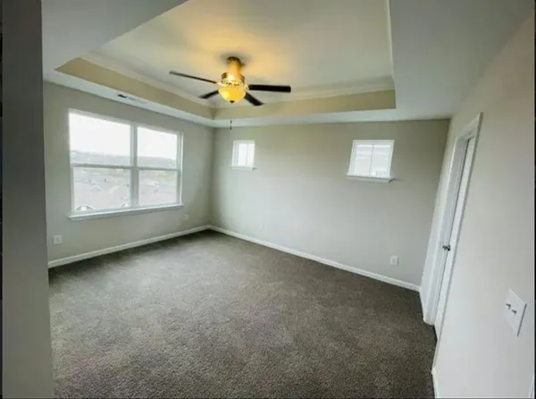 an empty room with windows and fan