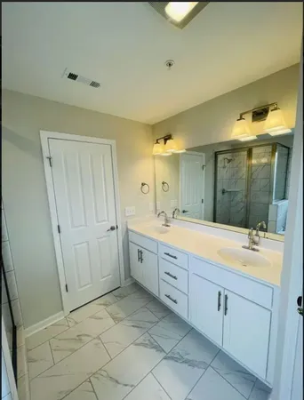 a spacious bathroom with a granite countertop sink mirror and a