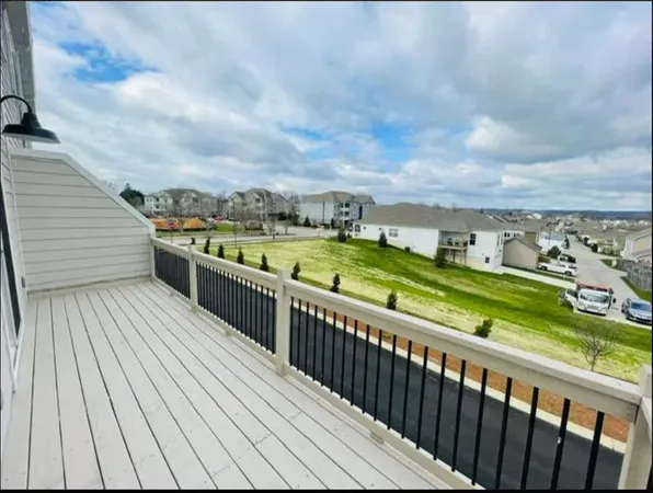 a view of a balcony with wooden floor & fence