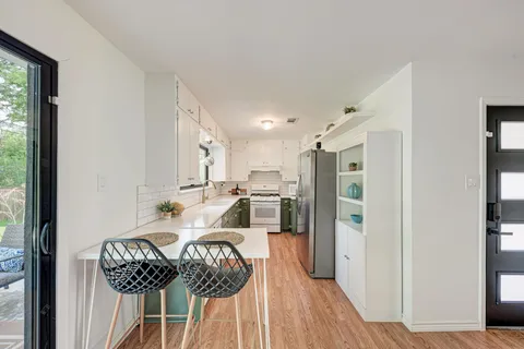 a kitchen with granite countertop a refrigerator and a wooden floor