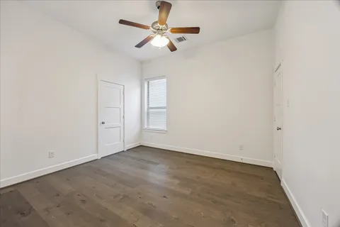 an empty room with a window and a ceiling fan