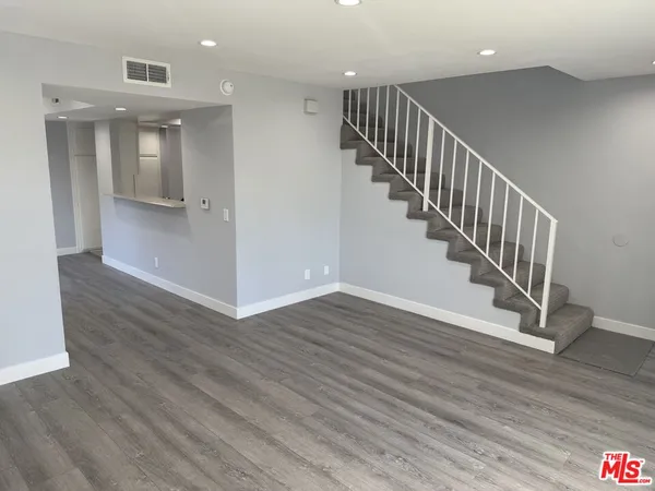 a view of staircase with white walls and wooden floor