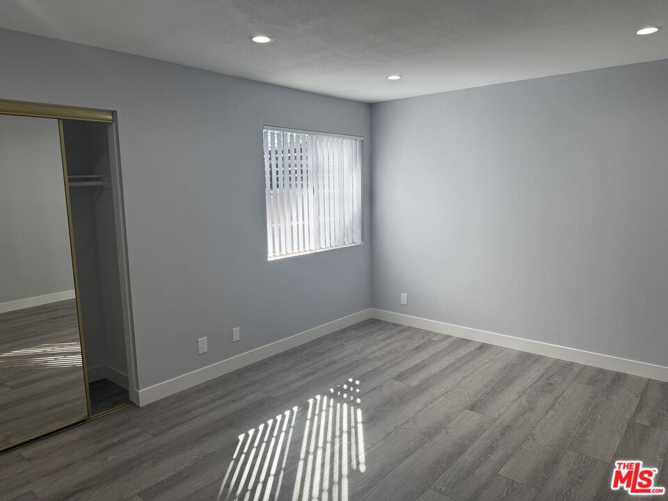 7639 Kester Avenue, Unit 1 Van Nuys, CA 91405 - Photo 15 of 21 a view of an empty room with wooden floor and a window