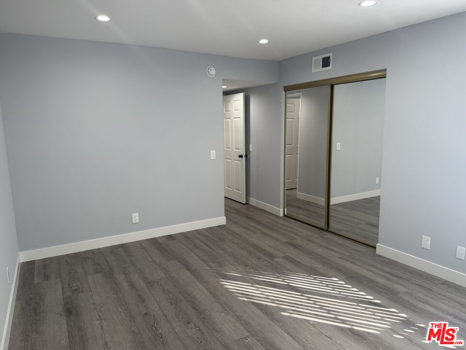 7639 Kester Avenue, Unit 1 Van Nuys, CA 91405 - Photo 16 of 21 a view of an empty room with wooden floor and closet