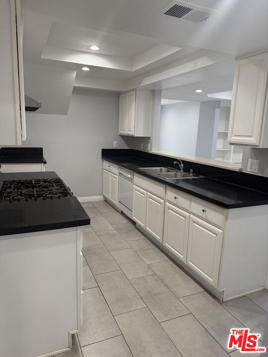 7639 Kester Avenue, Unit 1 Van Nuys, CA 91405 - Photo 5 of 21 a kitchen with granite countertop a stove and white cabinets
