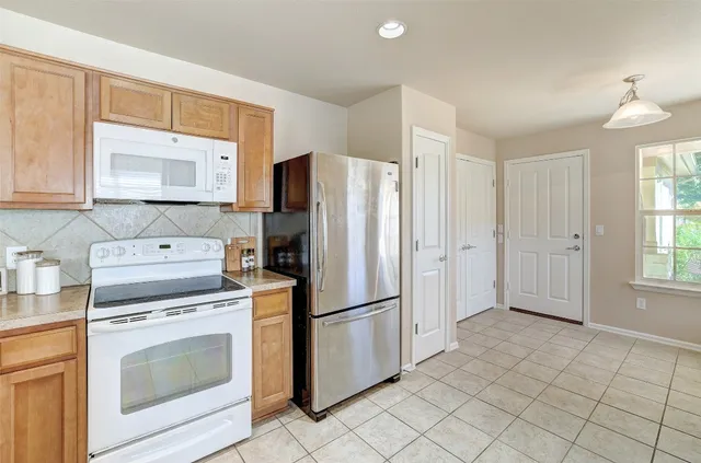 a kitchen with granite countertop a refrigerator stove and sink