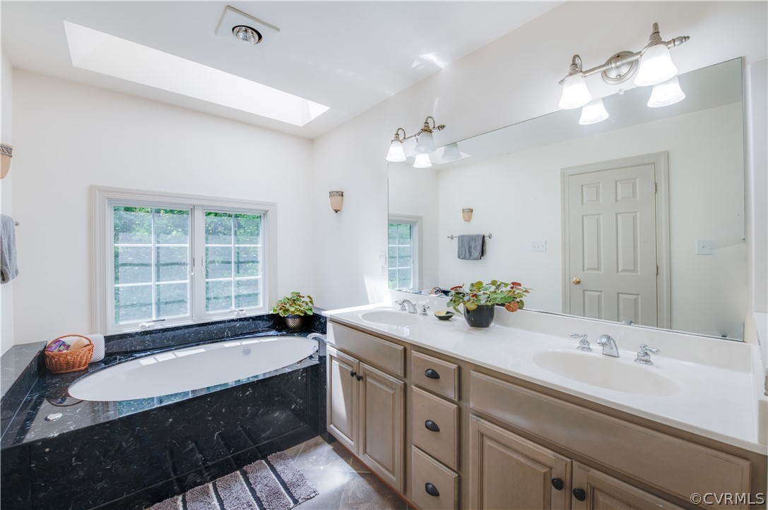3940 Whitehall Road Sandy Hook, VA 23153 - Photo 40 of 49 a bathroom with a tub double sink and a large mirror