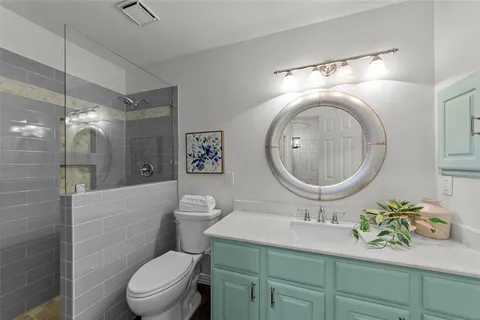 a bathroom with a toilet a sink and mirror