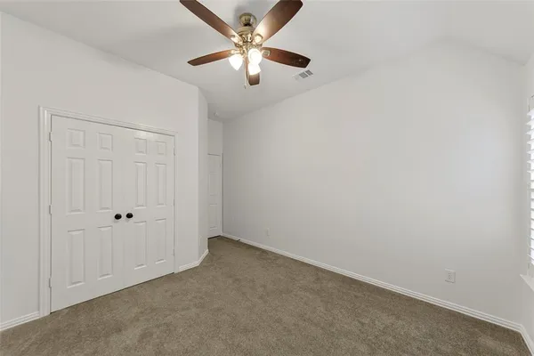 an empty room with chandelier fan