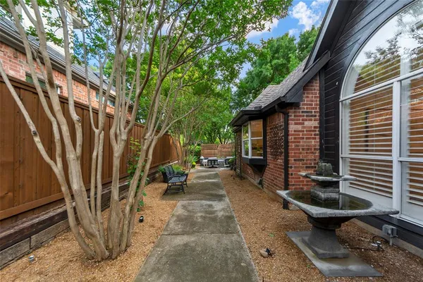 a view of a patio with table and chairs with wooden fence and plants