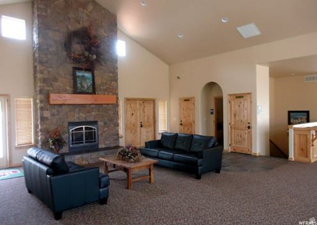 5168 Fairview Loop, Unit C604 Eden, UT 84310 - Photo 43 of 53 Living area with a stone fireplace, arched walkways, lofted ceiling, and carpet floors