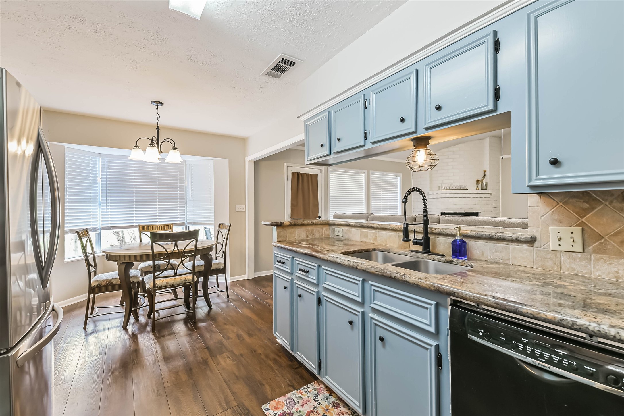 29319 Binefield Street Spring, TX 77386 - Photo 14 of 32 a kitchen with stainless steel appliances granite countertop a stove top oven a sink with dining table and chairs