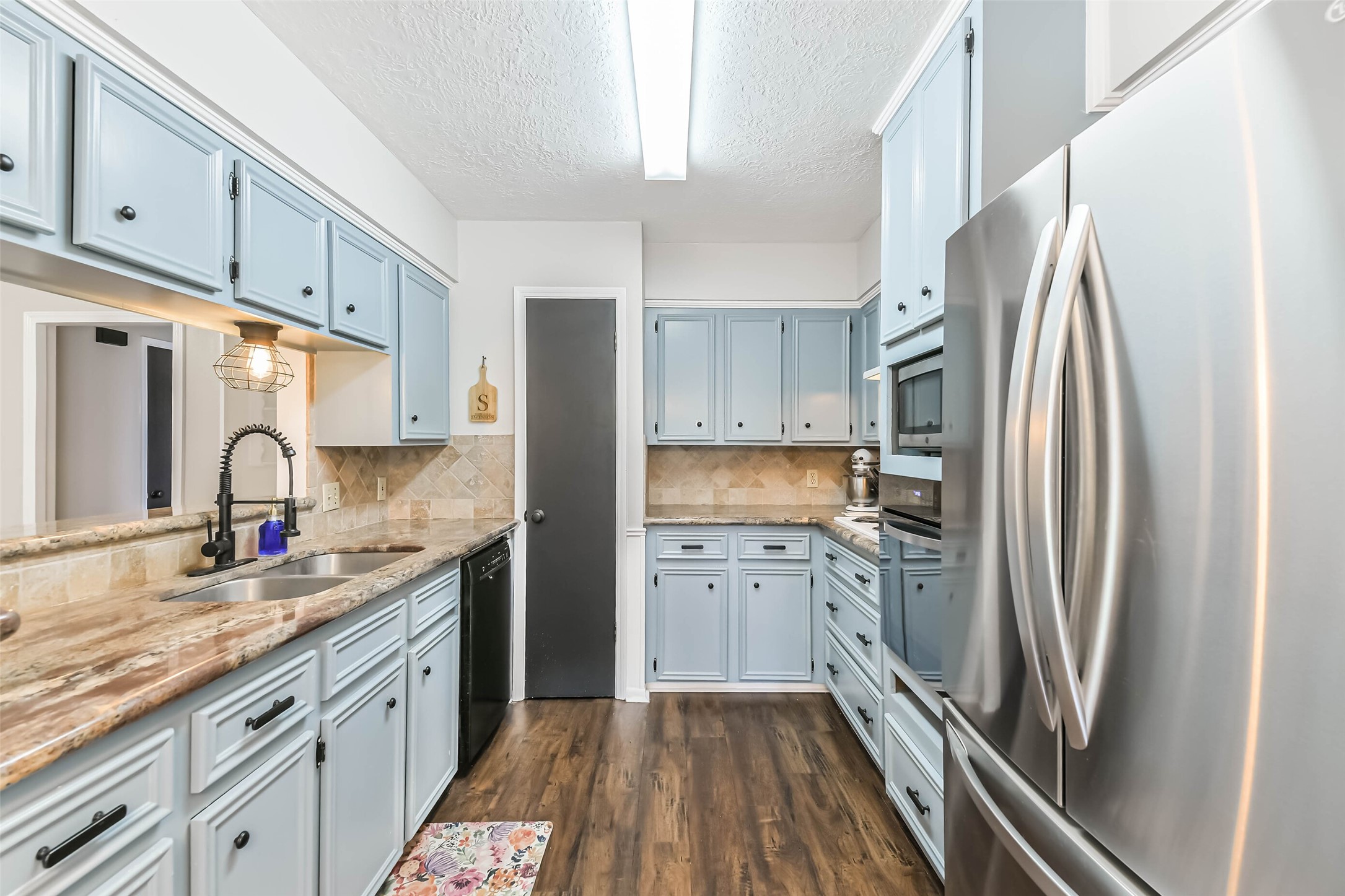 29319 Binefield Street Spring, TX 77386 - Photo 16 of 32 a kitchen with a sink a refrigerator and cabinets