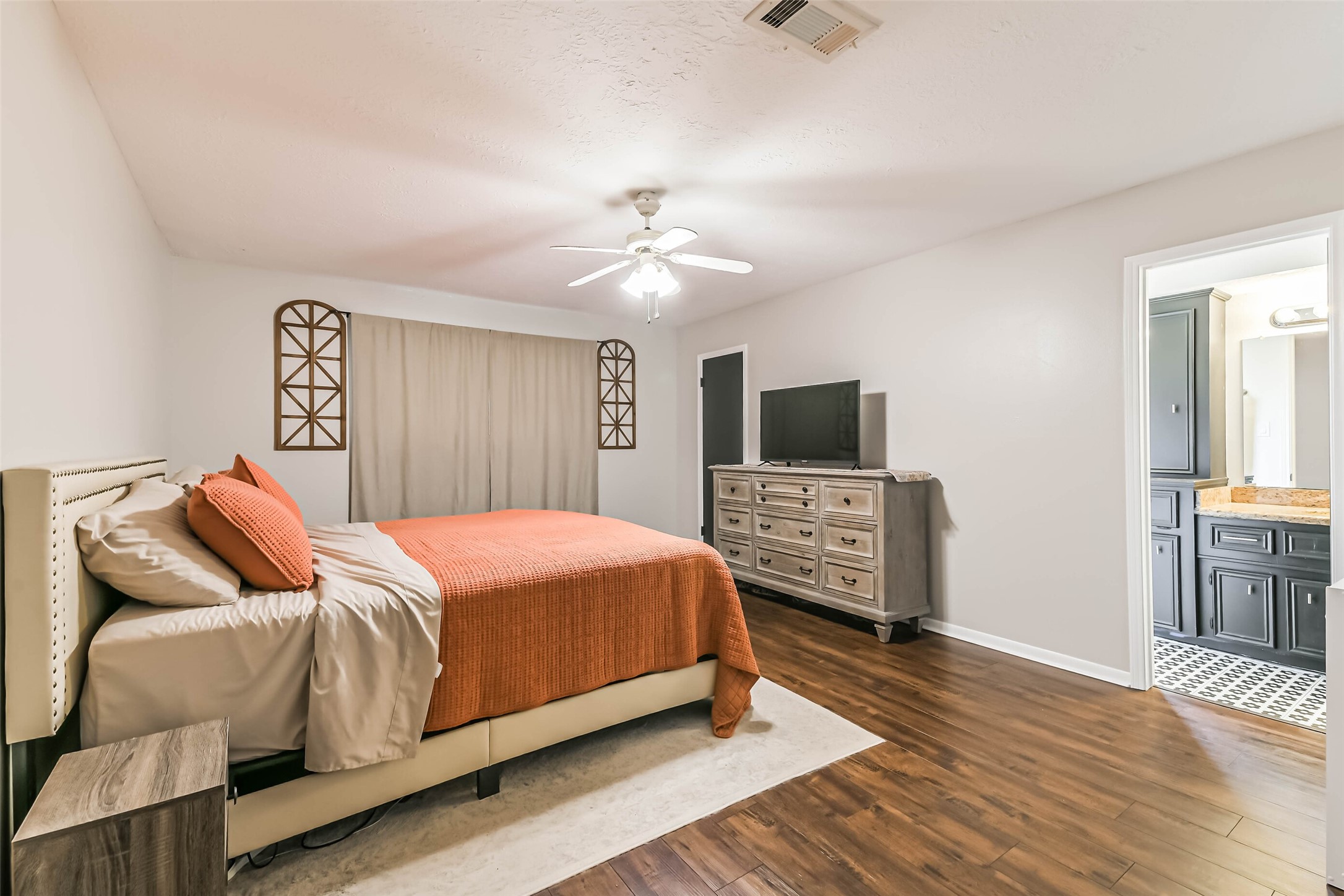 29319 Binefield Street Spring, TX 77386 - Photo 19 of 32 a bedroom with a bed a mirror on dresser and a chandelier