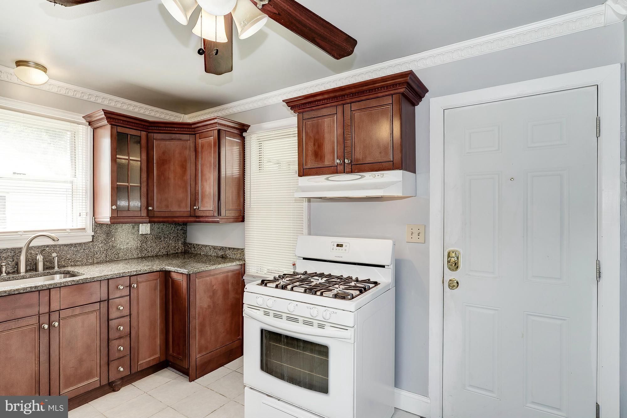 7925 Liberty Road Baltimore, MD 21244 - Photo 16 of 30 a kitchen with stainless steel appliances a stove microwave and cabinets