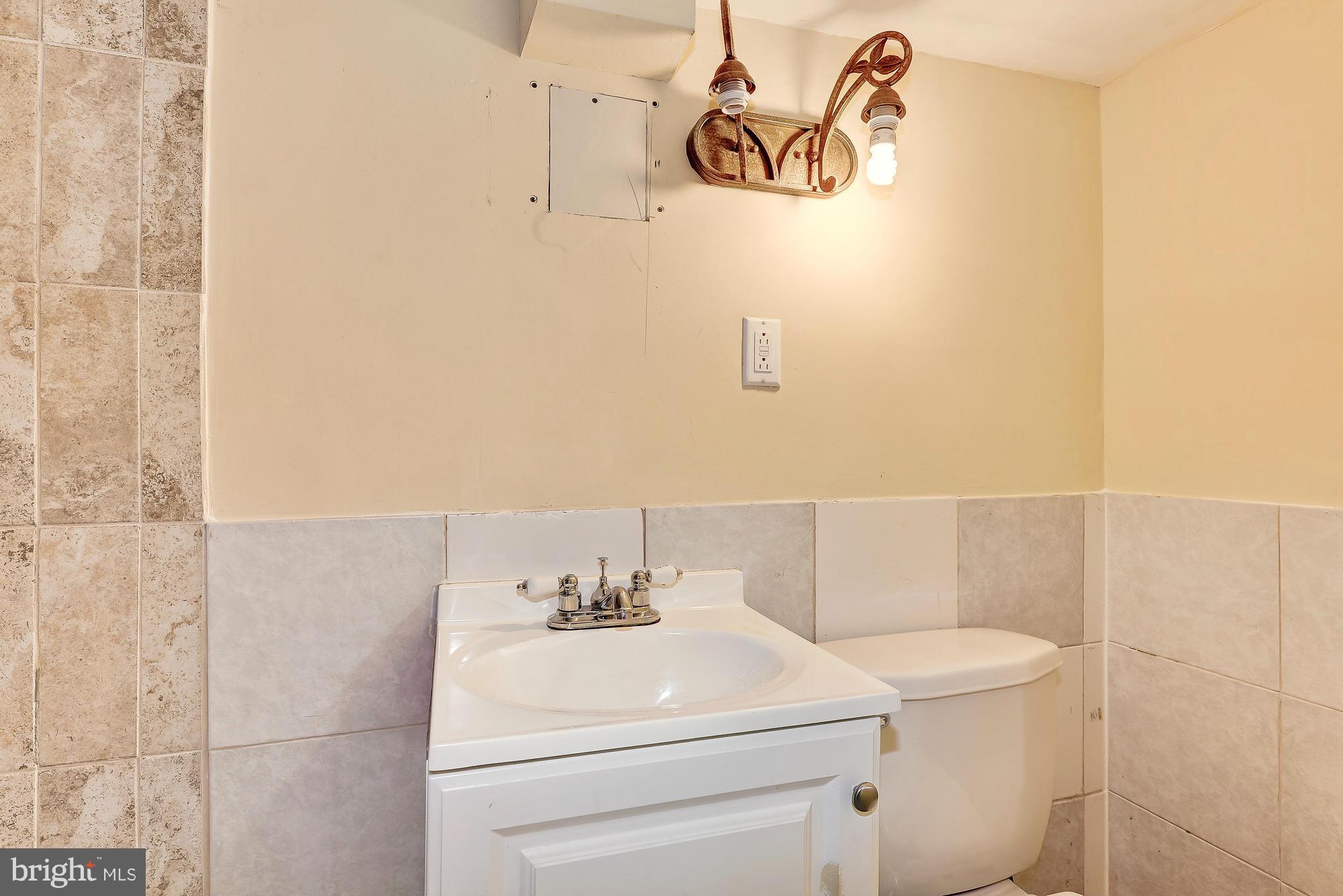 7925 Liberty Road Baltimore, MD 21244 - Photo 28 of 30 a bathroom with a sink a toilet and a shower curtain